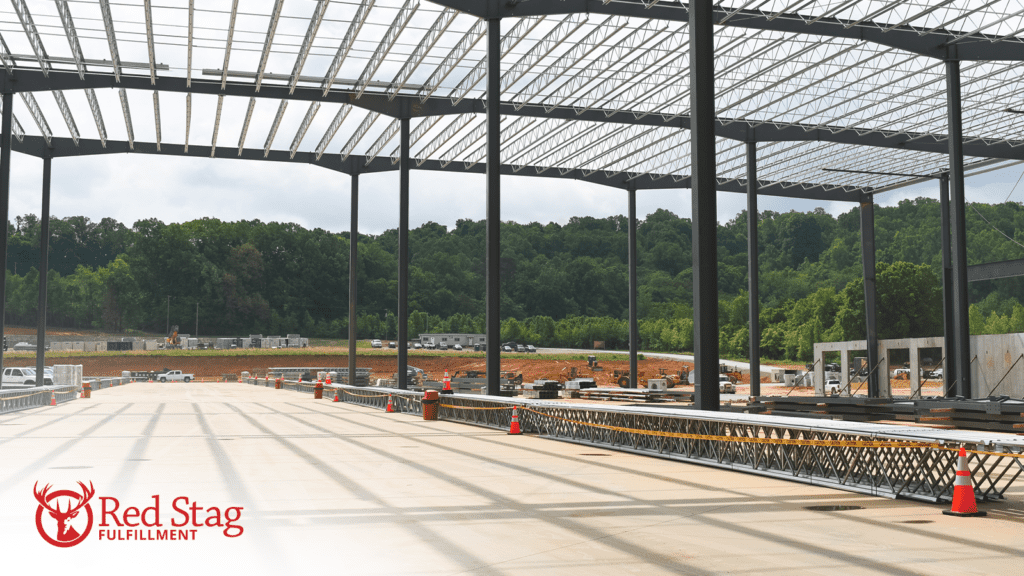 The first Sweetwater warehouse under construction with support pillars and roof beams in place and concrete being poured.