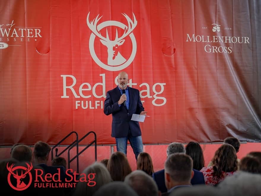 Red Stag CEO Dusty Holcomb standing on the stage inside half-constructed Sweetwater warehouse, thanking the Sweetwater community for proactively accepting Red Stag. 