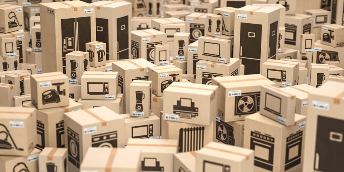 Household kitchen appliances in cardboard boxes in storage or warehouse. 