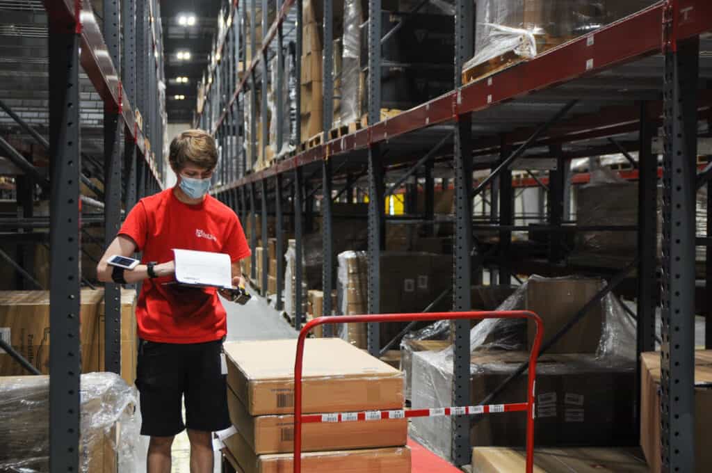 a warehouse worker checks a pick list for their order
